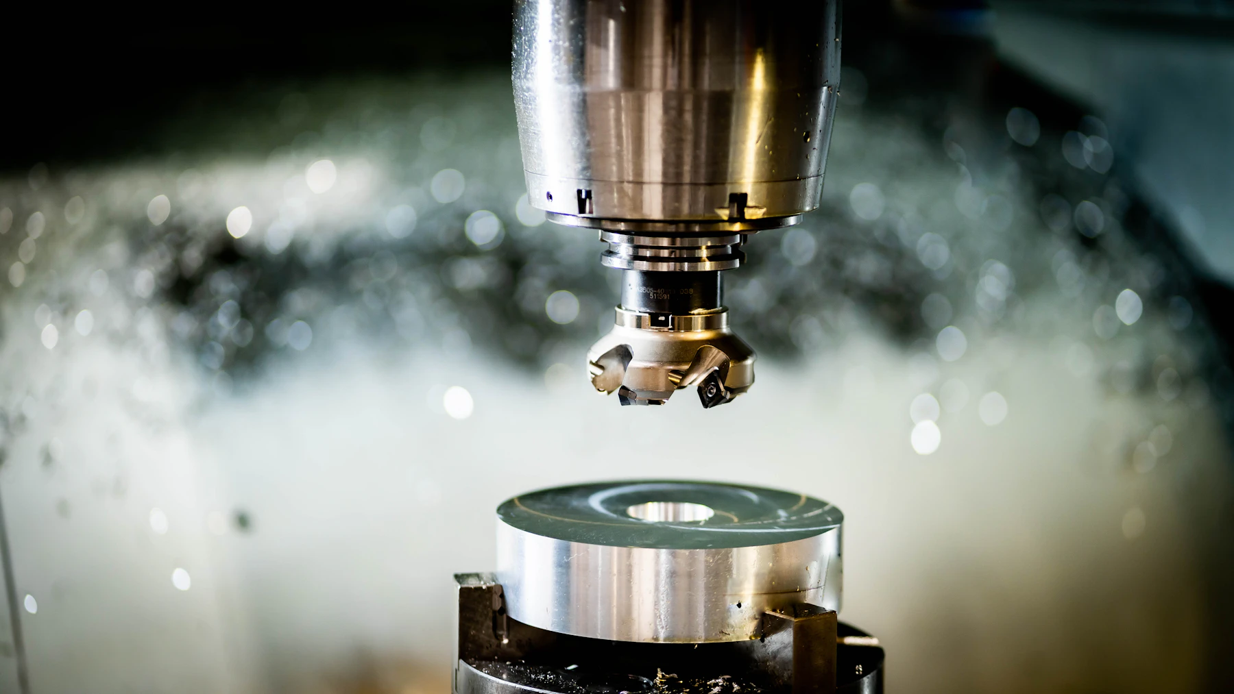 Precision milling equipment positioned over a circular metal workpiece