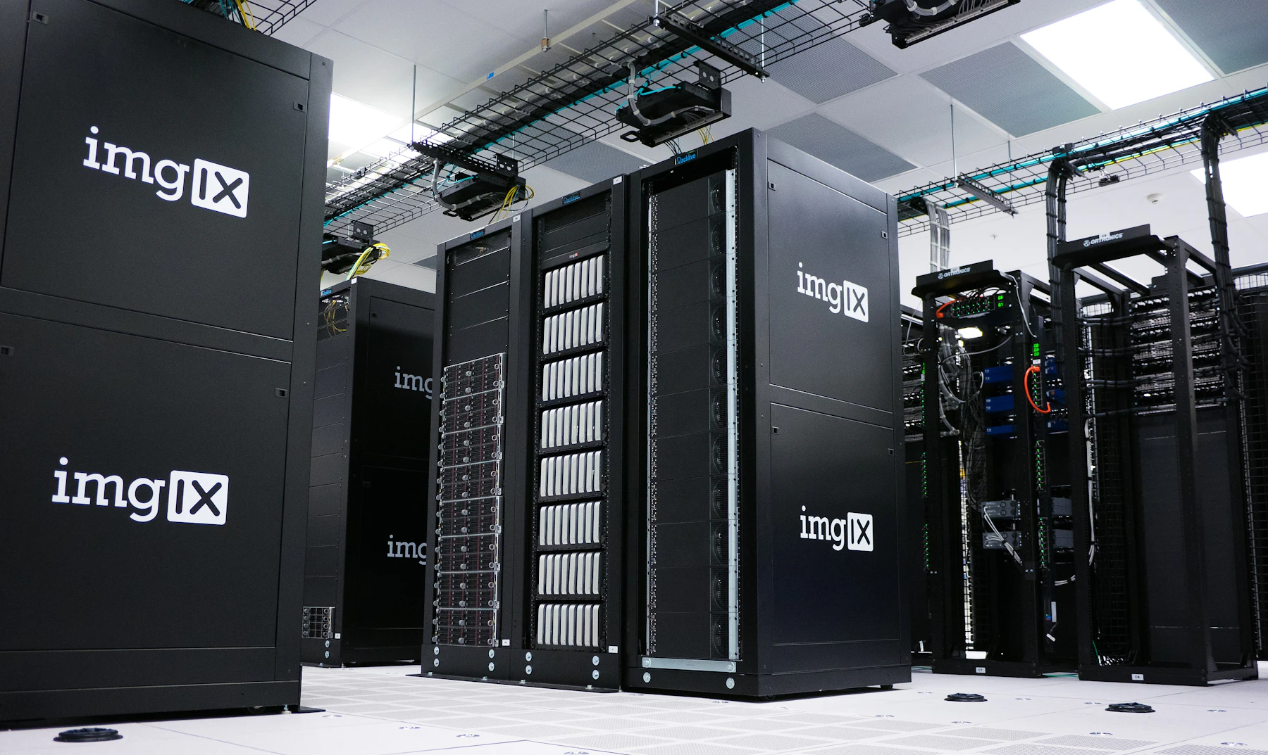 Rows of black server cabinets in a bright data centre