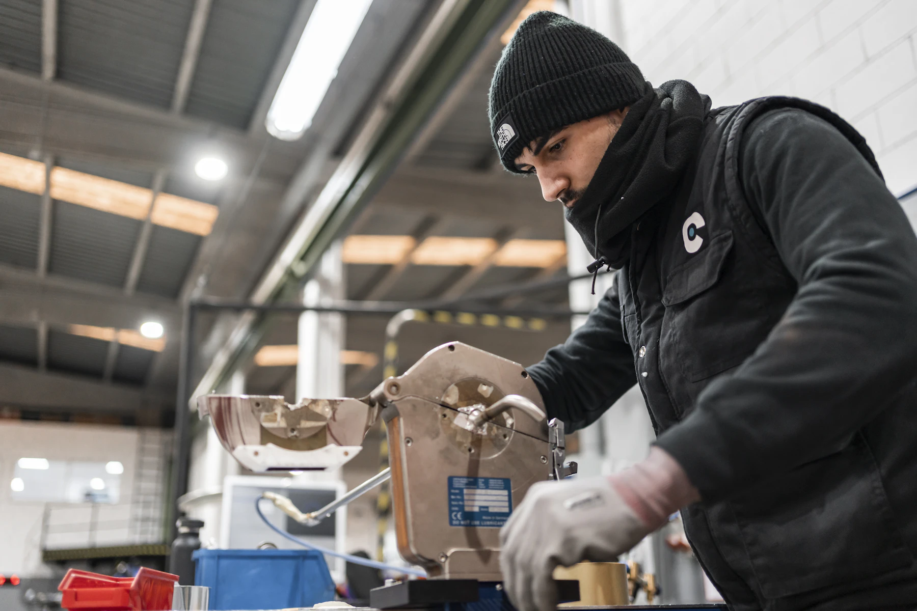 An industrial operator working with metal-cutting equipment in Girona, Spain
