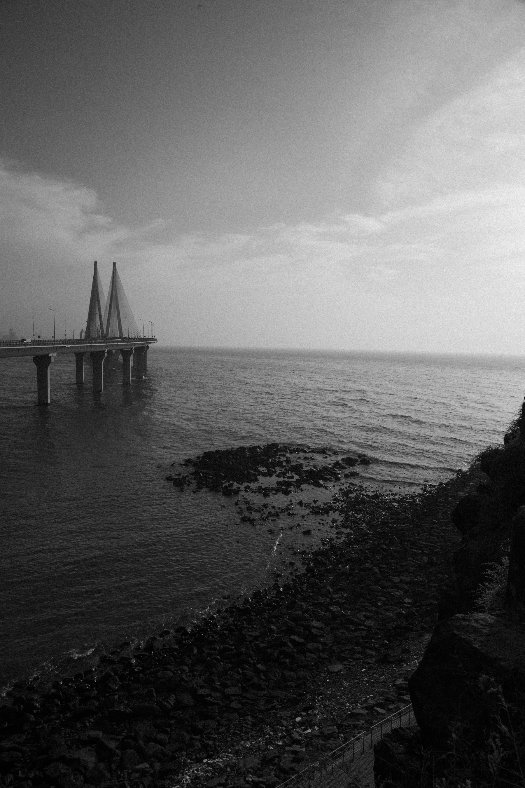 The cable-stayed Bandra-Worli Sea Link extending across the water in Mumbai, photographed in monochrome