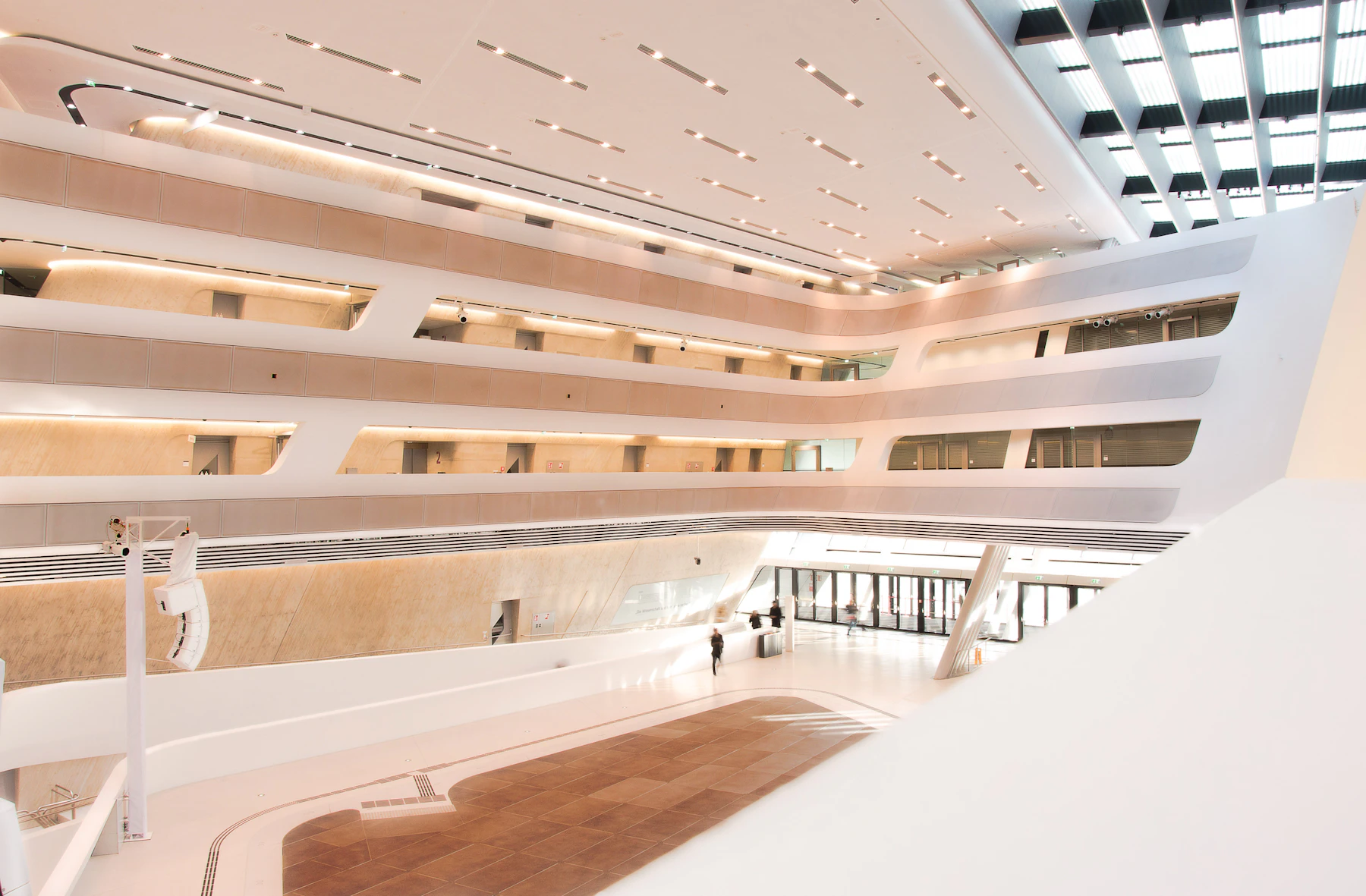 A light-filled architectural atrium with pale walls and warm timber details in Vienna